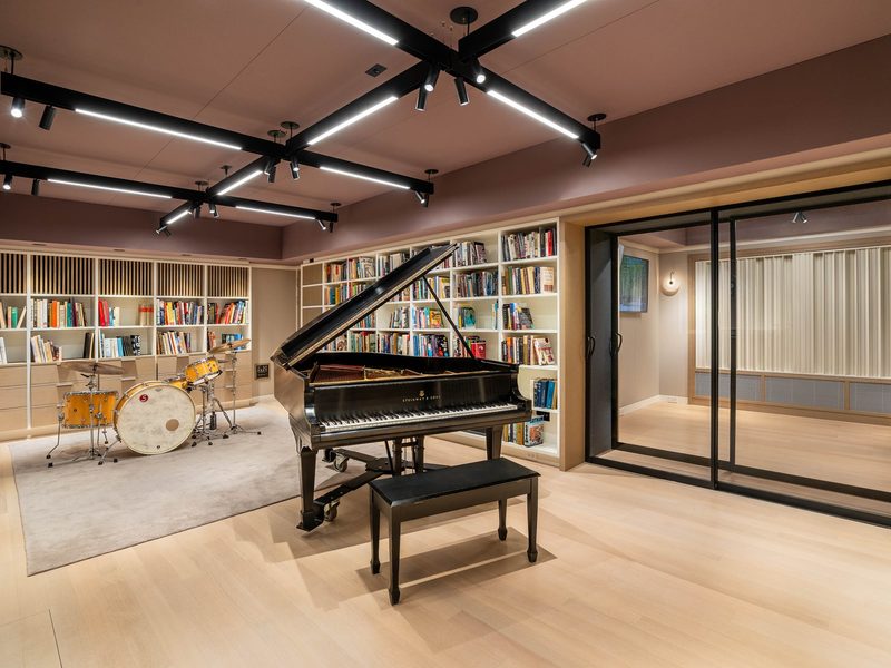 Live room with a Steinway grand piano, drum kit and library shelving
