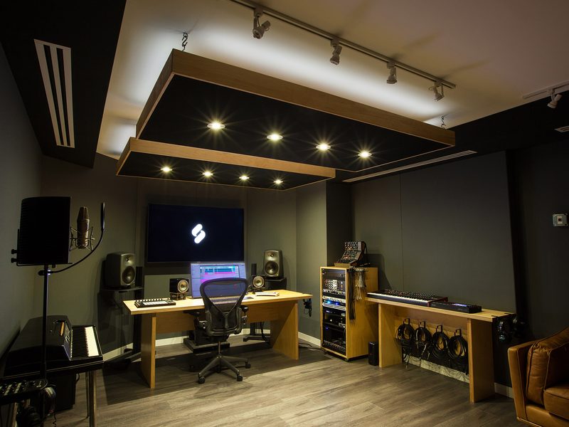 Production suite with a ceiling cloud, nearfield monitors and modular synth rack