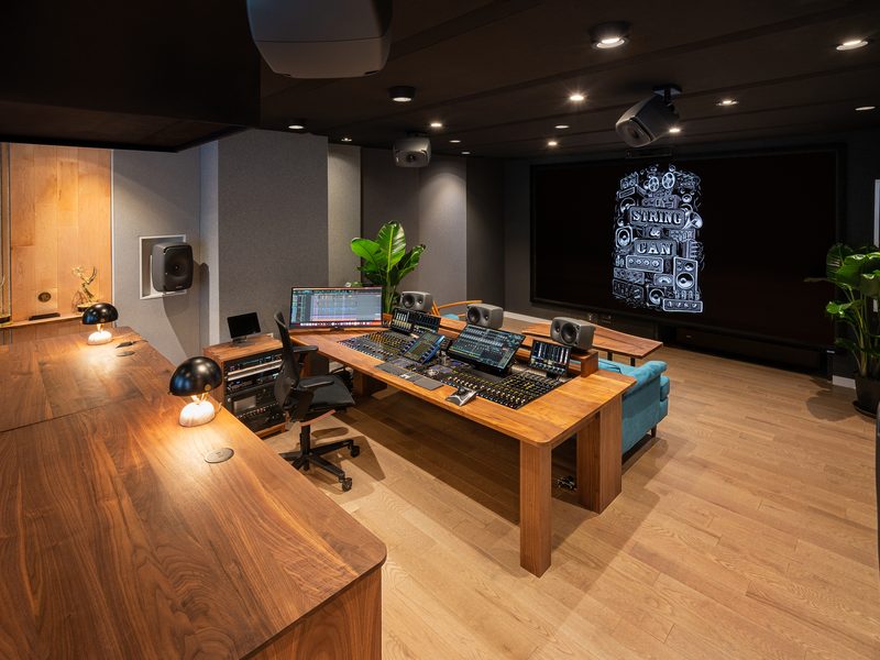 Mix stage with a walnut desk, immersive monitoring and projection screen